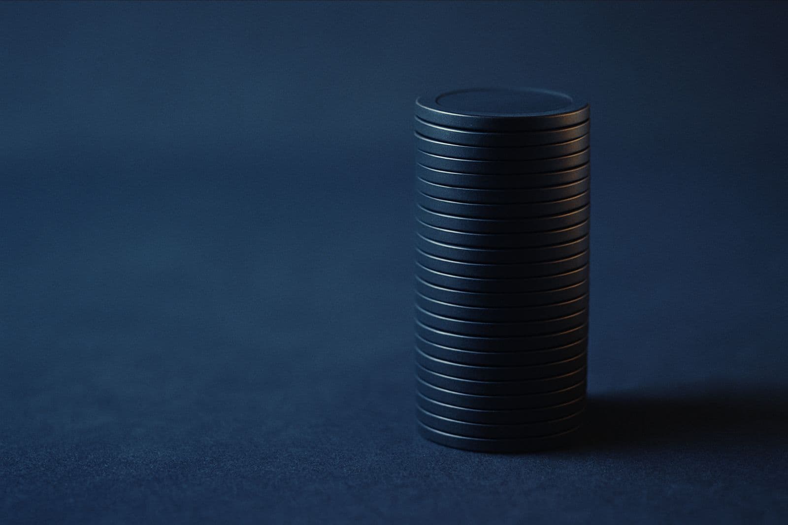 A single tall stack of chips on blue felt